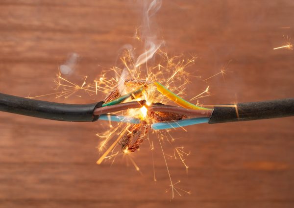 Sparks,Explosion,Between,Electrical,Cables,,On,Brown,Wooden,Background,,Fire